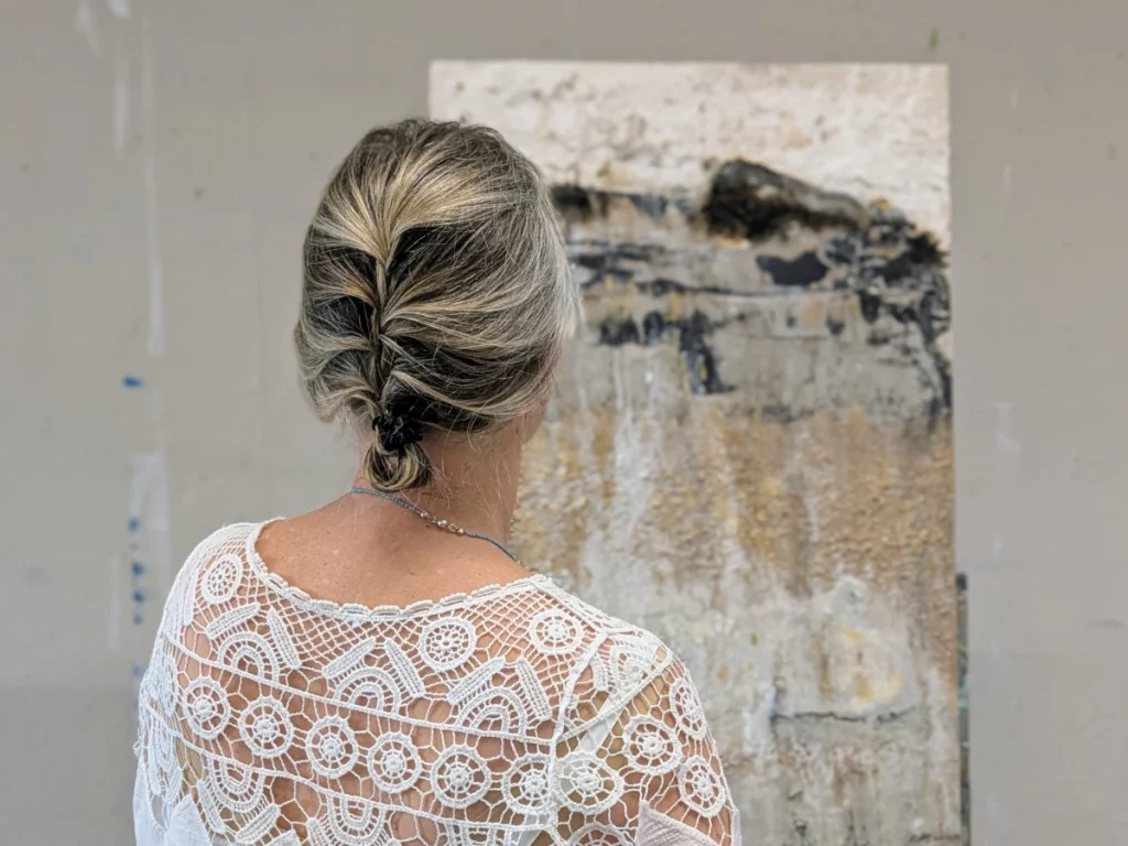 Sabine Huber betrachtet ein Werk ihrer abstrakten Naturmalerei im Atelier bei München.